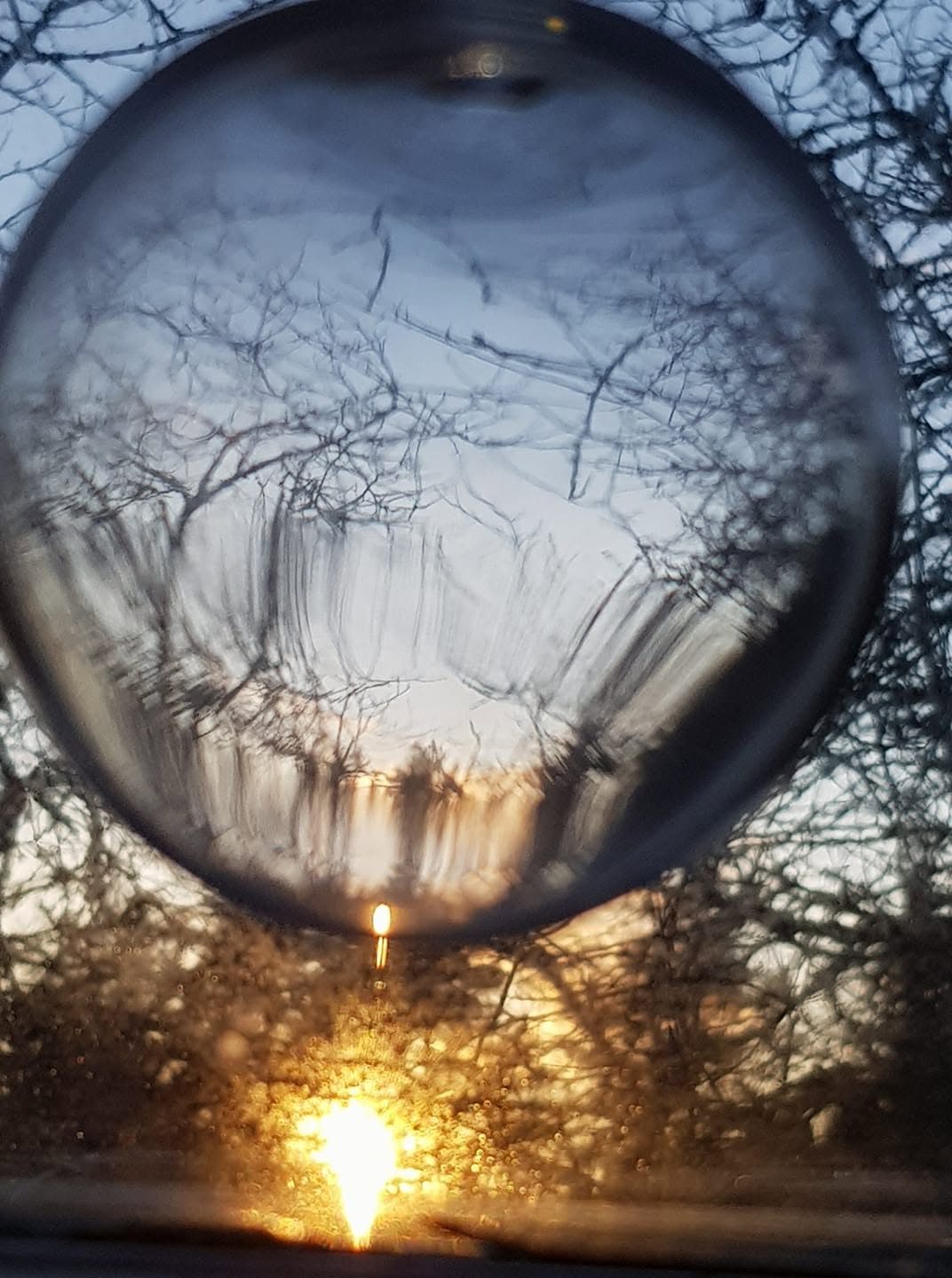 Lasipallo, jossa heijastuu auringonlasku